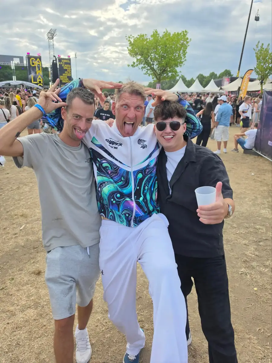 Three ravers at a festival, one in an HCM tracksuit